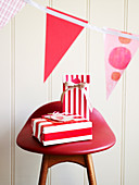 Gift parcels in red and white striped wrapping paper on a stool