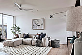 Modern sofa in the living room in natural tones with high pile carpet