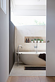 Open sliding door to the bathroom with a free-standing tub under the window