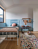 Metal bed in the children's room with two-tone wall