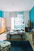 Vintage furniture in bedroom with bright blue walls