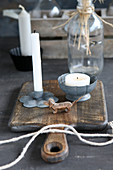 Candles in metal holders on chopping board