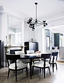 Upholstered chairs around oval dining table in elegant gray dining room