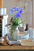 Gnarled root and delphiniums in glass vase