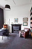 Leather armchairs next to fireplace in study