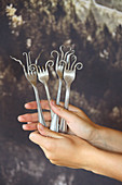 Artfully bent forks held in hands