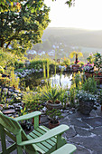 Kleine Terrasse mit Adirondack-Sessel am Gartenteich