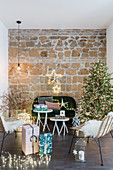 Festively decorated living room with exposed stone wall