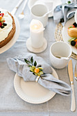 Place setting with linen napkin and cape gooseberry on table set for afternoon coffee