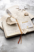 Aufgeschlagener Taschenkalender auf Astrologiebuch mit Deko-Stern