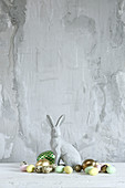 Easter bunny and eggs against grey rendered wall