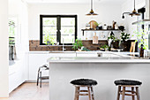 Kitchen counter used as partition in open-plan kitchen with rustic accessories