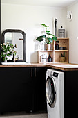 Black cupboards and vintage accessories in utility room