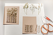 Handcrafting a garden fence of tiny twigs and dried flowers