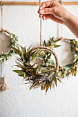 Hand-tied wreaths of dried leaves, flowers and grasses