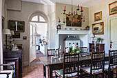 18th century oak table and Yorkshire chairs in dining room with terracotta flooring and ceiling candelabra