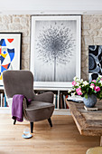 Grey armchair in front of picture of dandelion clock in living room