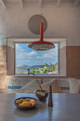 Stone bowls on dining table in front of panoramic window