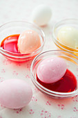 Pink eggs in bowls of dye
