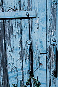 Abgeblätterte blaue Farbe an einer Holztür