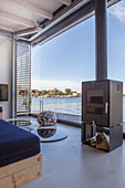 Modern houseboat: log burner in front of glass wall