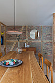 Dining area in front of brick wall in open-plan interior
