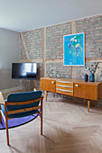 TV and sideboard in living room with brick wall
