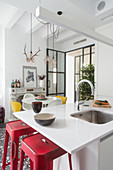 White kitchen counter and red bar stools