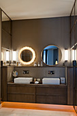 Two round mirrors above twin washstand in bathroom