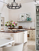 Bowl of flowers on island counter in bright country-house kitchen