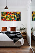 Colorful picture over the bed in the simple bedroom