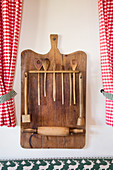 Wooden board repurposed to store kitchen utensils