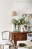 Flowers and Champagne on festive sideboard seen across dining table