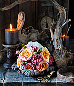 Bouquet of roses, lit candles and dried branches