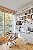 White shelves above white desk and swivel chair with striped upholstery next to balcony doors