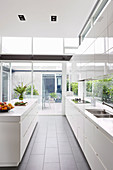 White high-gloss kitchen in architect's house with window fronts