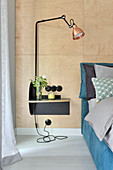 Lamps on bedside table against wall clad in plywood panels