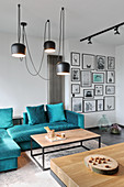 Turquoise velvet sofa and coffee table next to gallery of pictures