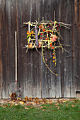 Imaginative, autumnal flower arrangement on barn door