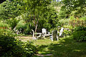 Sitzgruppe mit Deckchairs auf der Wiese im sommerlichen Garten