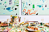 Colorfully laid Christmas table, abstract murals in the background