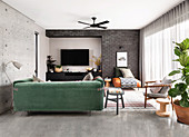 Green velvet sofa in the living room with concrete and brick wall