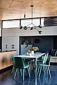 Green chairs at the dining table in the kitchen in the architect's house