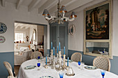 Silverware candlesticks on dining table with corner cabinet and 18th century French trumeau mirror