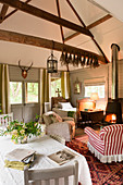 Cosy interior of small cottage with wood-burning stove and antique armchairs
