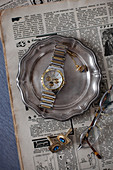 Old newspaper, vintage pewter plate, wristwatch, jewellery and spectacles