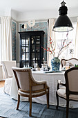 Stylish chairs, display cabinet and wallpaper in dining room