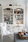 Armchair in front of bookcase with library ladder and tray on ottoman