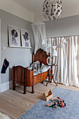 Antique, dark wood cot in front of doorway covered by curtain