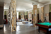 Pool table in open-plan interior with marble pillars